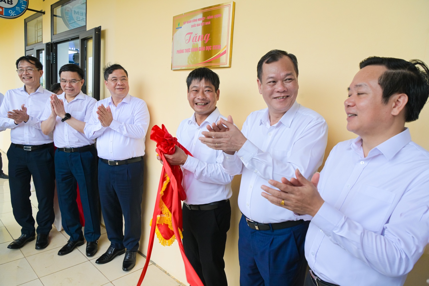 Các đại biểu thực hiện nghi thức gắn biển công trình phòng thực hành STEM
