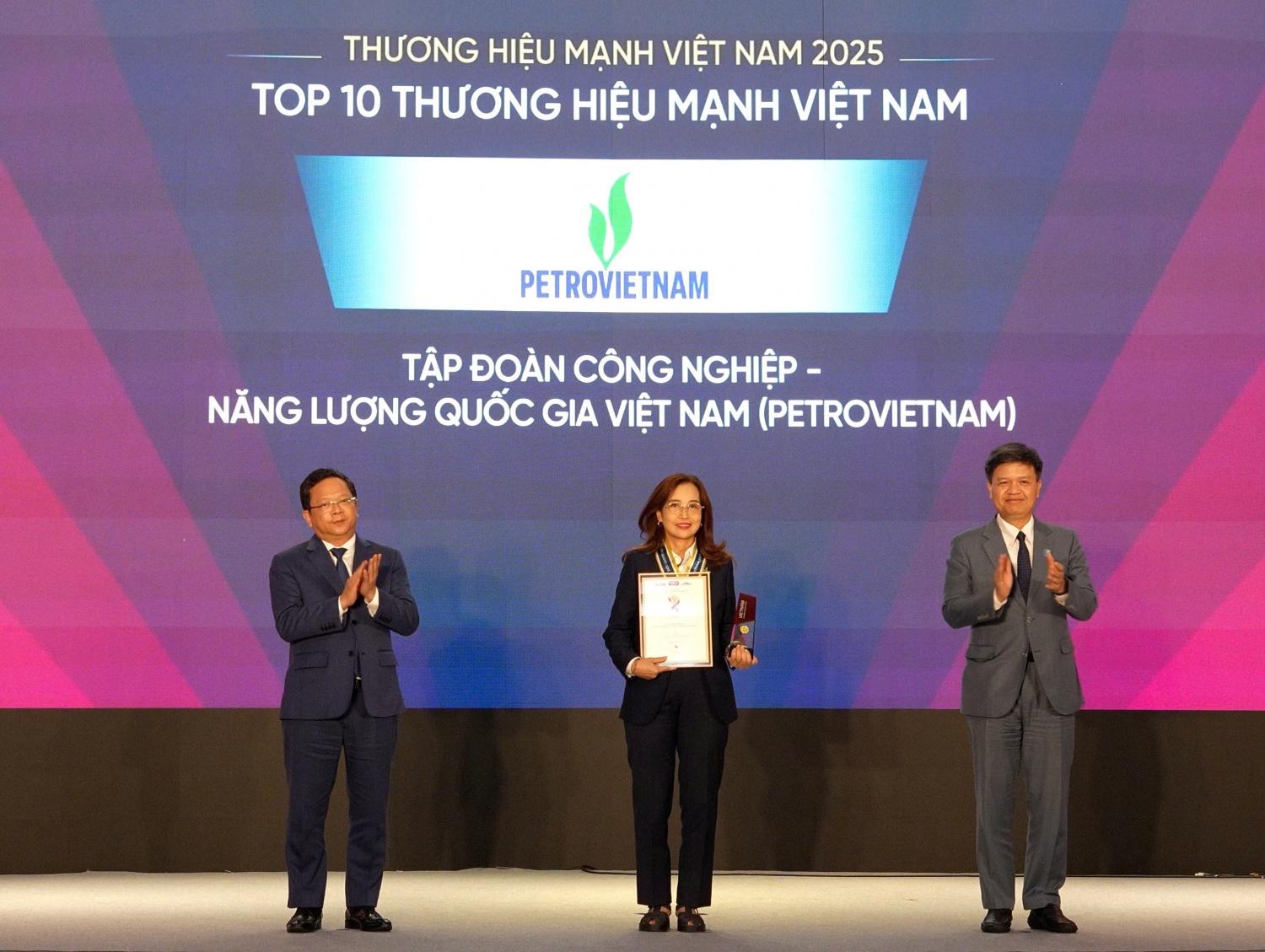 Ông Tạ Đình Thi, Phó Chủ nhiệm Ủy ban Khoa học, Công nghệ và Môi trường của Quốc hội và ông Nguyễn Đức Hiển, Phó Trưởng Ban Chính sách, chiến lược Trung ương trao bảng và cup vinh danh cho đại diện Petrovietnam - bà Nguyễn Việt Nga - Phó Trưởng Ban Truyền thông và Văn hóa doanh nghiệp Tập đoàn.