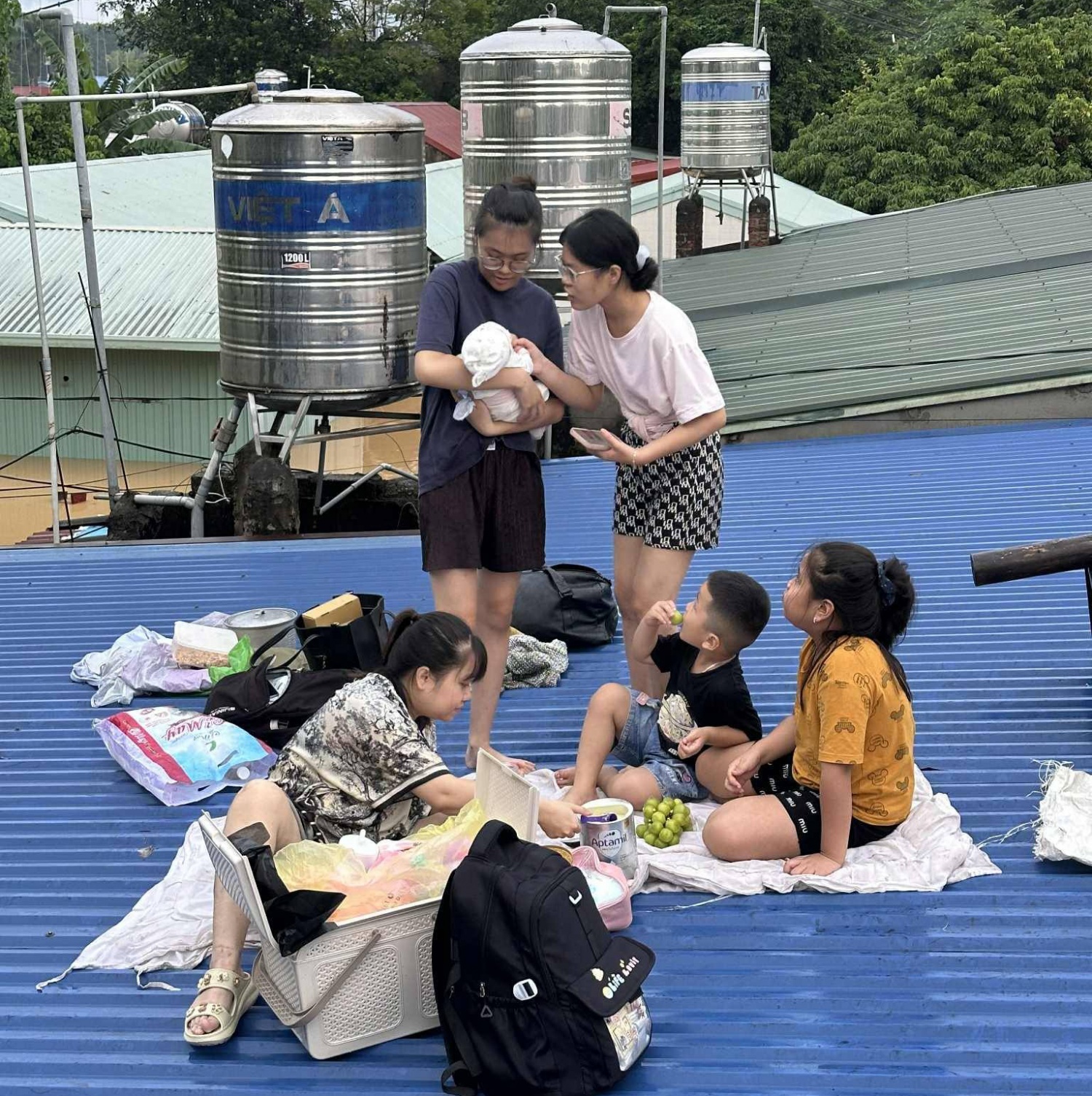 Mực nước dâng cao, người dân phải trèo lên mái nhà chờ cứu hộ.