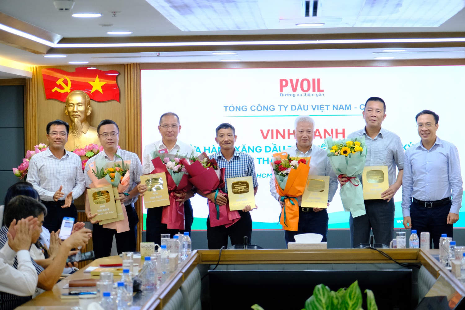 Đồng chí Lê Văn Nghĩa – Thành viên HĐQT PVOIL (bên trái) và đồng chí Hoàng Đình Tùng – UV BTV Đảng ủy, Phó Tổng Giám đốc PVOIL (bên phải) trao biểu trưng vinh danh cho đại diện các đơn vị có CHXD tiêu biểu