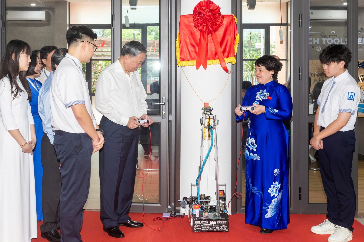 Tổng Bí thư Tô Lâm và Hiệu trưởng Trường THPT chuyên Hà Nội - Amsterdam sử dụng công nghệ robot do các em học sinh trực tiếp chế tạo kéo băng khánh thành phòng học STEM.