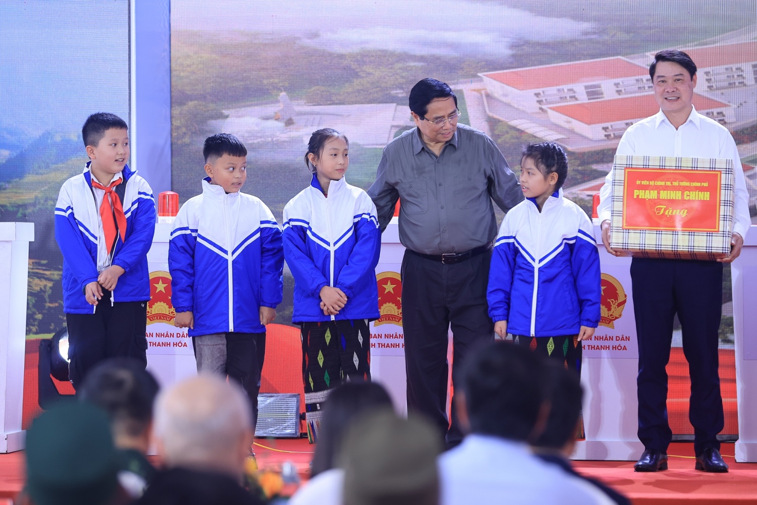 Thủ tướng Phạm Minh Chính trao quà tặng cùng áo ấm cho các em học sinh tại lễ khởi công.