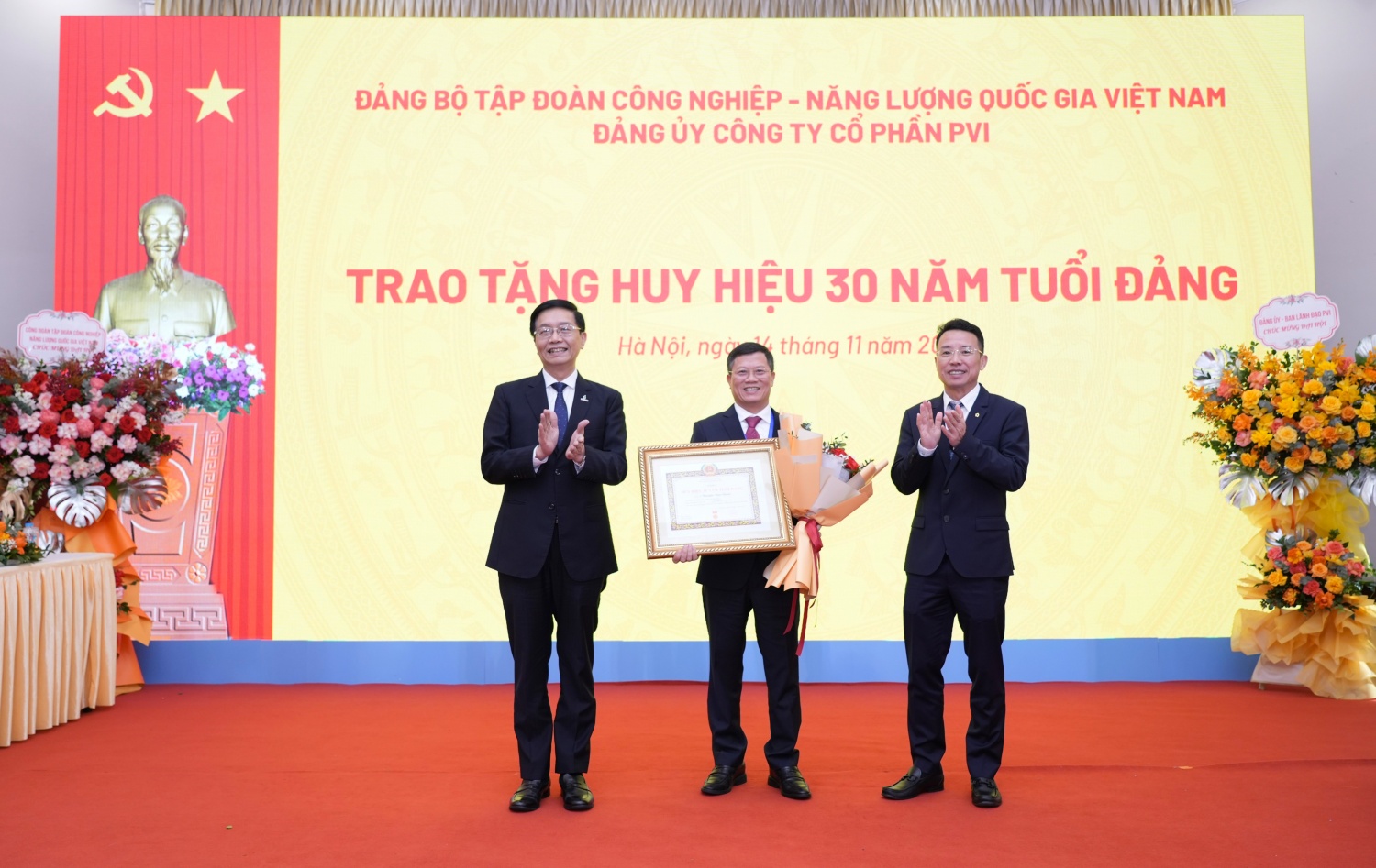 Đồng chí Trần Quang Dũng, Phó Bí thư Thường trực Đảng ủy Petrovietnam và đồng chí Nguyễn Tuấn Tú, Bí thư Đảng uỷ, Phó Chủ tịch HĐQT, Tổng Giám đốc PVI trao tặng huy hiệu 30 năm tuổi đảng cho đảng viên Nguyễn Văn Chỉnh.