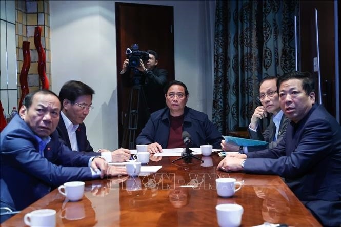 Thủ tướng Phạm Minh Chính họp trực tuyến từ Nam Phi chỉ đạo khắc phục hậu quả mưa lũ. (Ảnh: TTXVN)