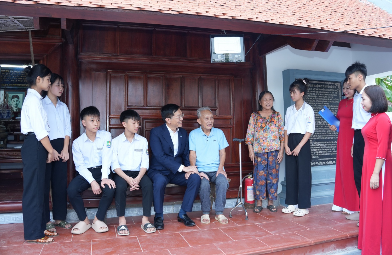 Đồng chí Trần Quang Dũng cùng ông Nguyễn Sỹ Thiêm - em trai Liệt sĩ Nguyễn Sỹ Sách trò chuyện với các em học sinh trường THCS Thanh Lương.