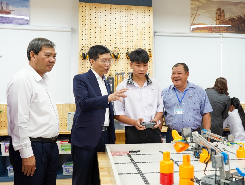 Ông Trần Quang Dũng và ông Kim Ngọc Thái, Phó Bí thư Tỉnh ủy, Chủ tịch Ủy ban Mặt trận Tổ quốc Việt Nam tỉnh Vĩnh Long (bìa trái) cùng các đại biểu tham quan, chia sẻ với thầy cô và các em học sinh tại phòng STEM vừa được khánh thành.