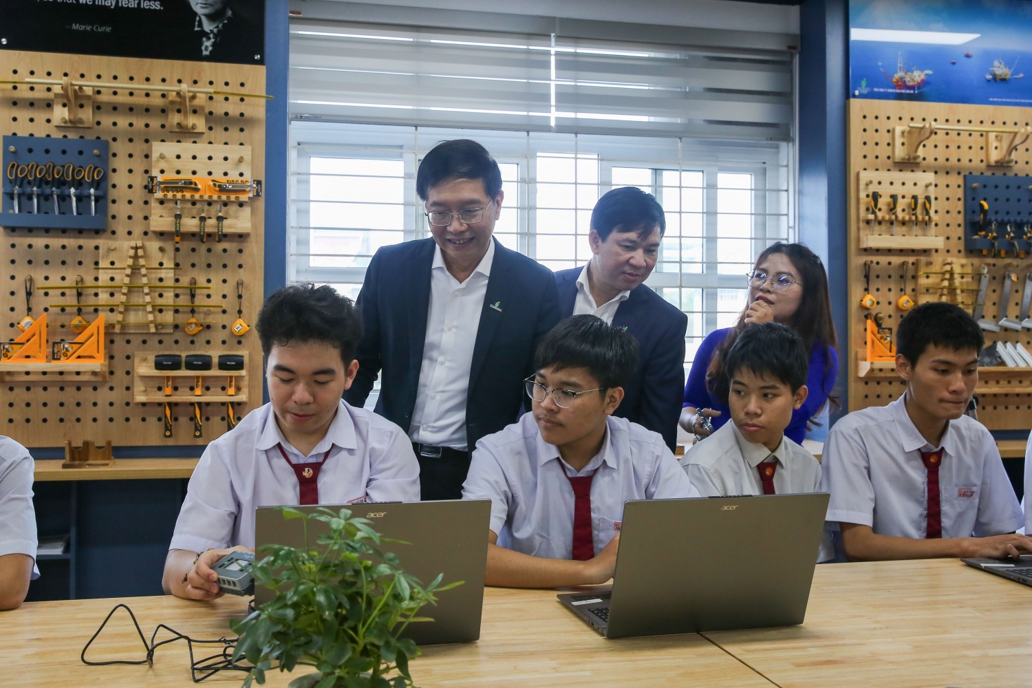 Đồng chí Trần Quang Dũng và đồng chí Đinh Trọng Huy thăm hỏi, trò chuyện cùng các em học sinh đang trải nghiệm tại phòng STEM.