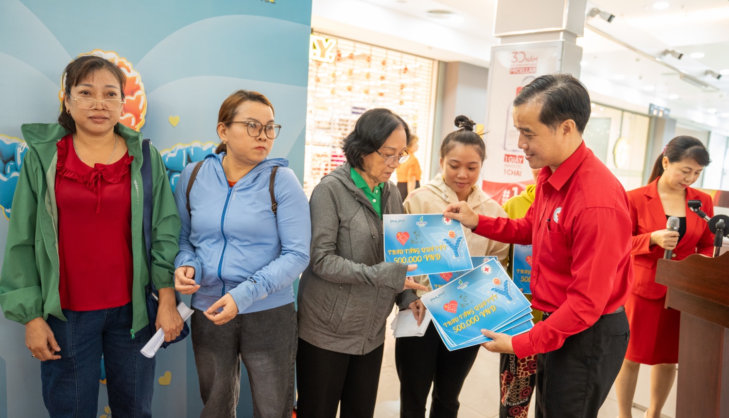 Ông Tống Xuân Giang - Phó Chủ tịch Hội Chữ thập đỏ TP HCM trao quà cho người dân.
