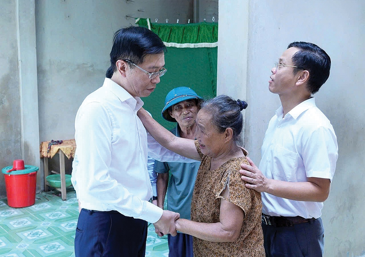 Đồng chí Trần Quang Dũng, Phó Bí thư Thường trực Đảng ủy Tập đoàn động viên, chia sẻ với người dân bị ảnh hưởng bởi bão số 10 ở Hà Tĩnh