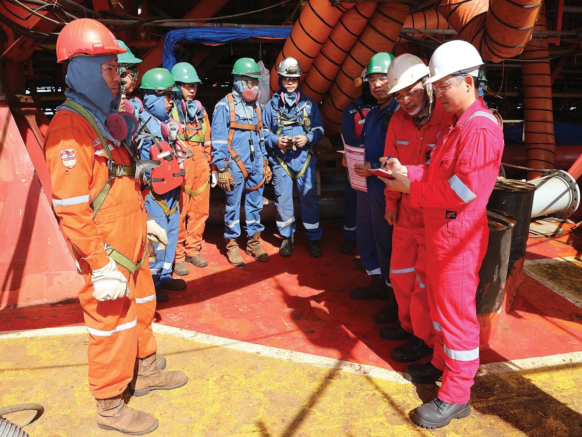 Anh Trần Đại Nghĩa (bìa phải) trao đổi kế hoạch với nhà thầu trước khi triển khai công tác vận hành - bảo dưỡng trên tàu FPSO AMD TGT1