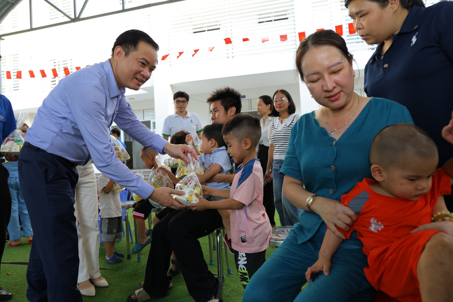 Đồng chí Lê Ngọc Sơn trao quà cho các em nhỏ đang được nuôi dưỡng ở Trung tâm