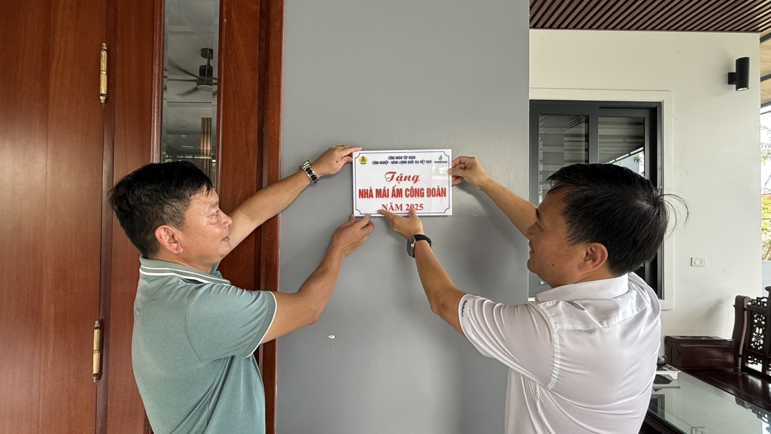 Đồng chí Vũ Anh Tuấn gắn biển công trình và bàn giao nhà mới cho gia đình anh Lê Viết Việt.