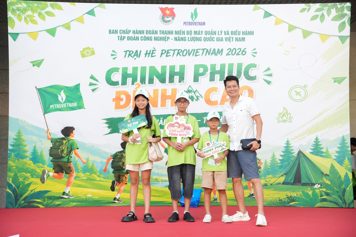 Phụ huynh và con em chụp hình lưu niệm trước chuyến đi trại hè.