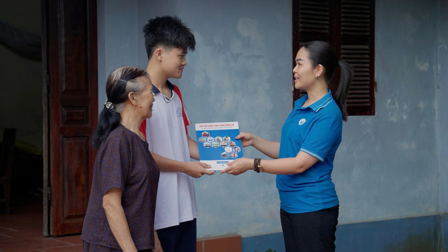 Đại diện Quỹ học bổng Thắp Sáng Niềm Tin trao chứng nhận học bổng cho em Nguyễn Quốc Phòng.